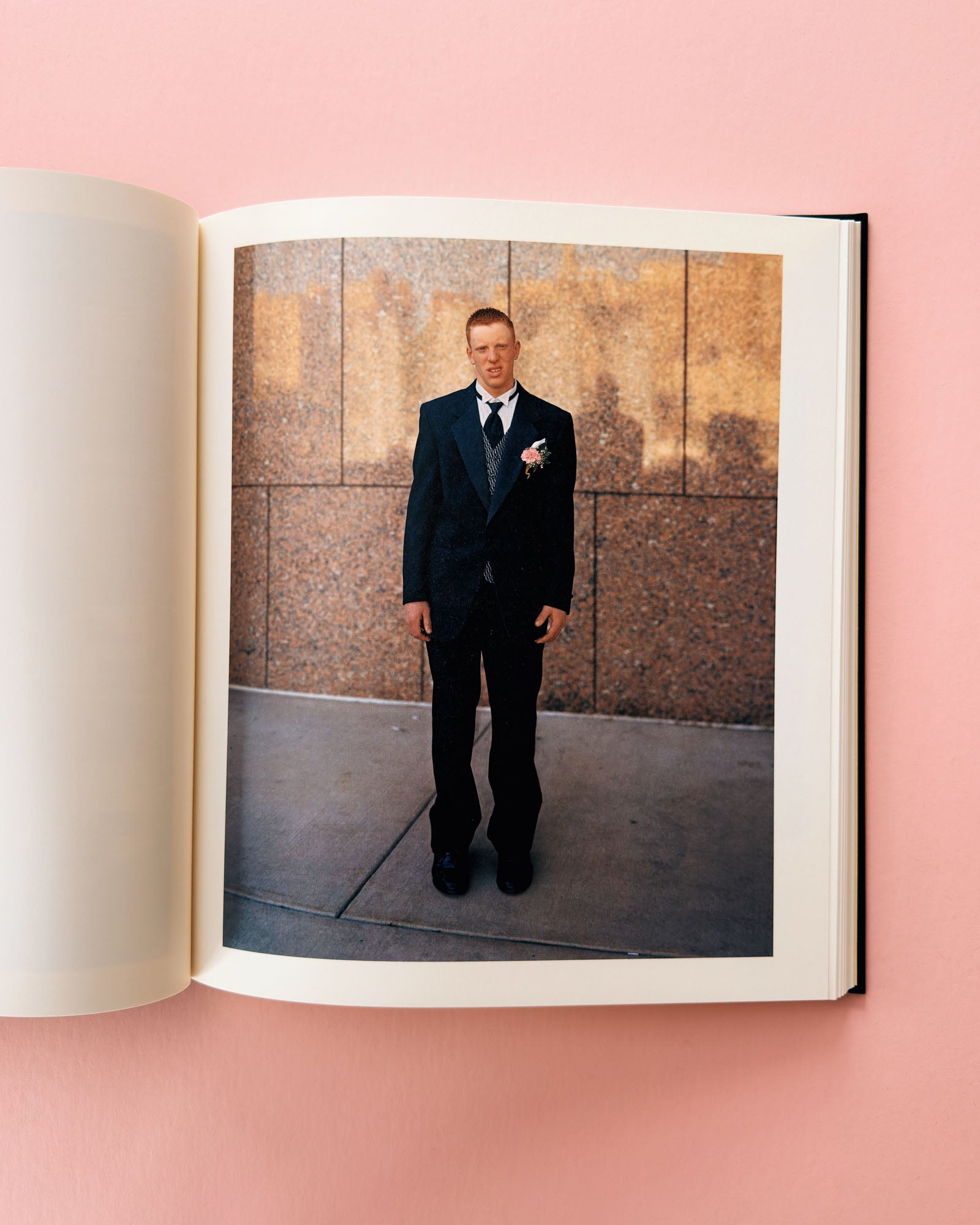Open book showing a photo of a man in a suit against a textured wall. Classic photo book Niagara by Alec Soth. Made with large format film photography.